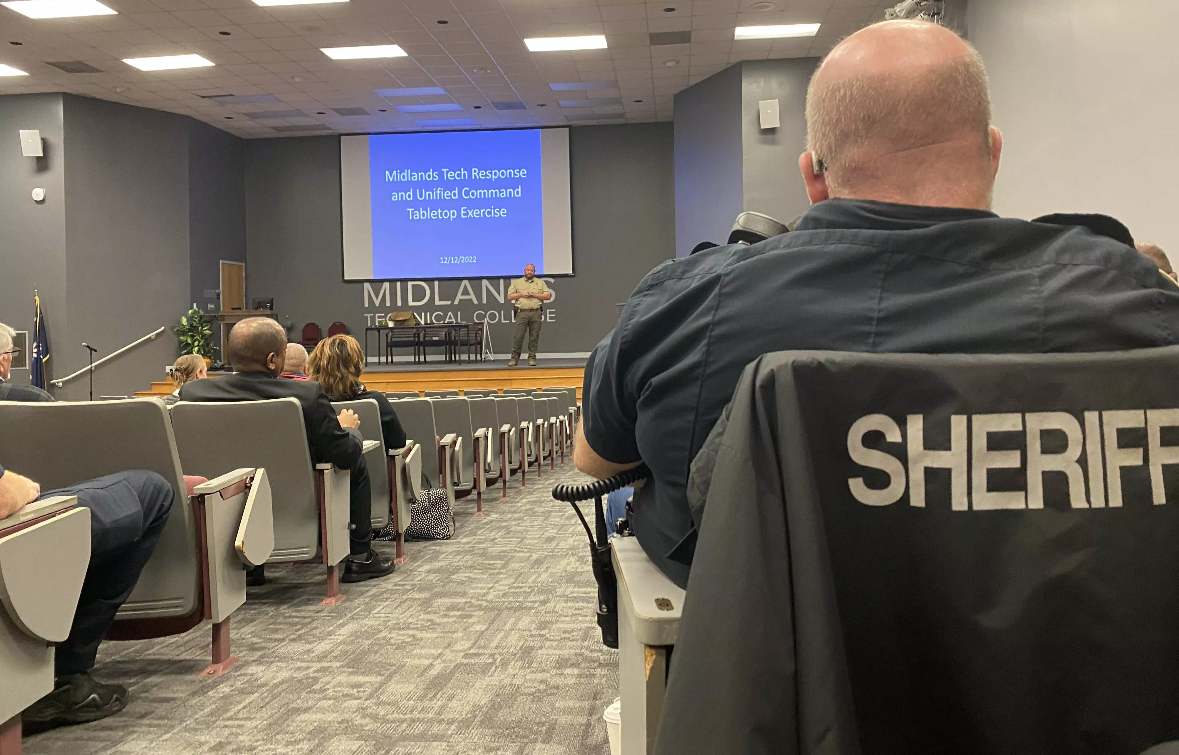 Sheriff and other professionals sitting in an auditorium watching safety presentation