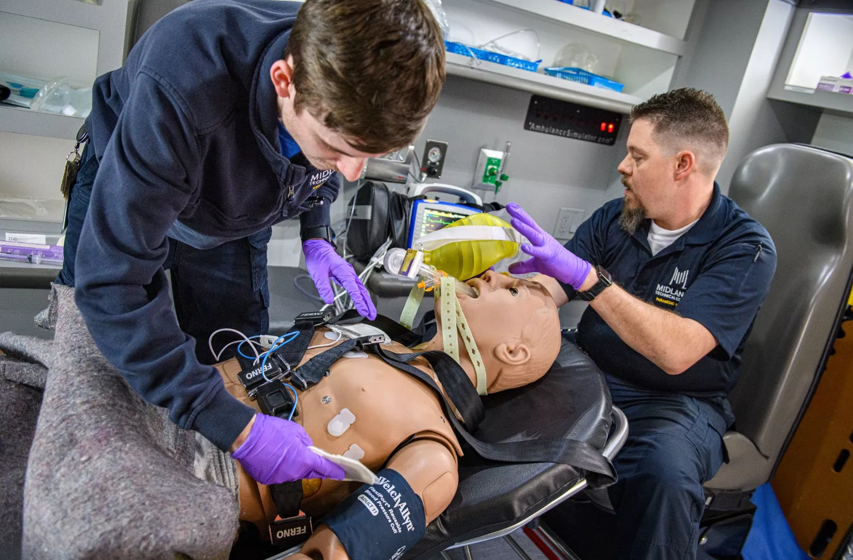 Image of Midlands Technical College EMT students practicing and learning on a medical dummy in the mobile ambulance unit on the Airport Campus. 